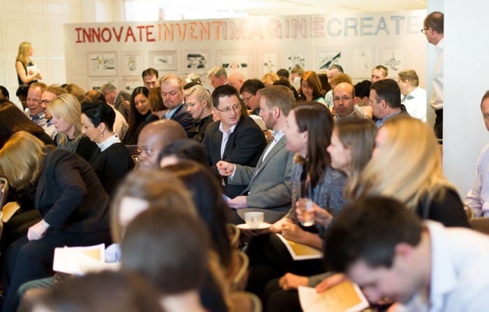 Crowded meeting with engaged participants.