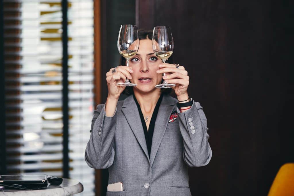 Woman holding two wine glasses up